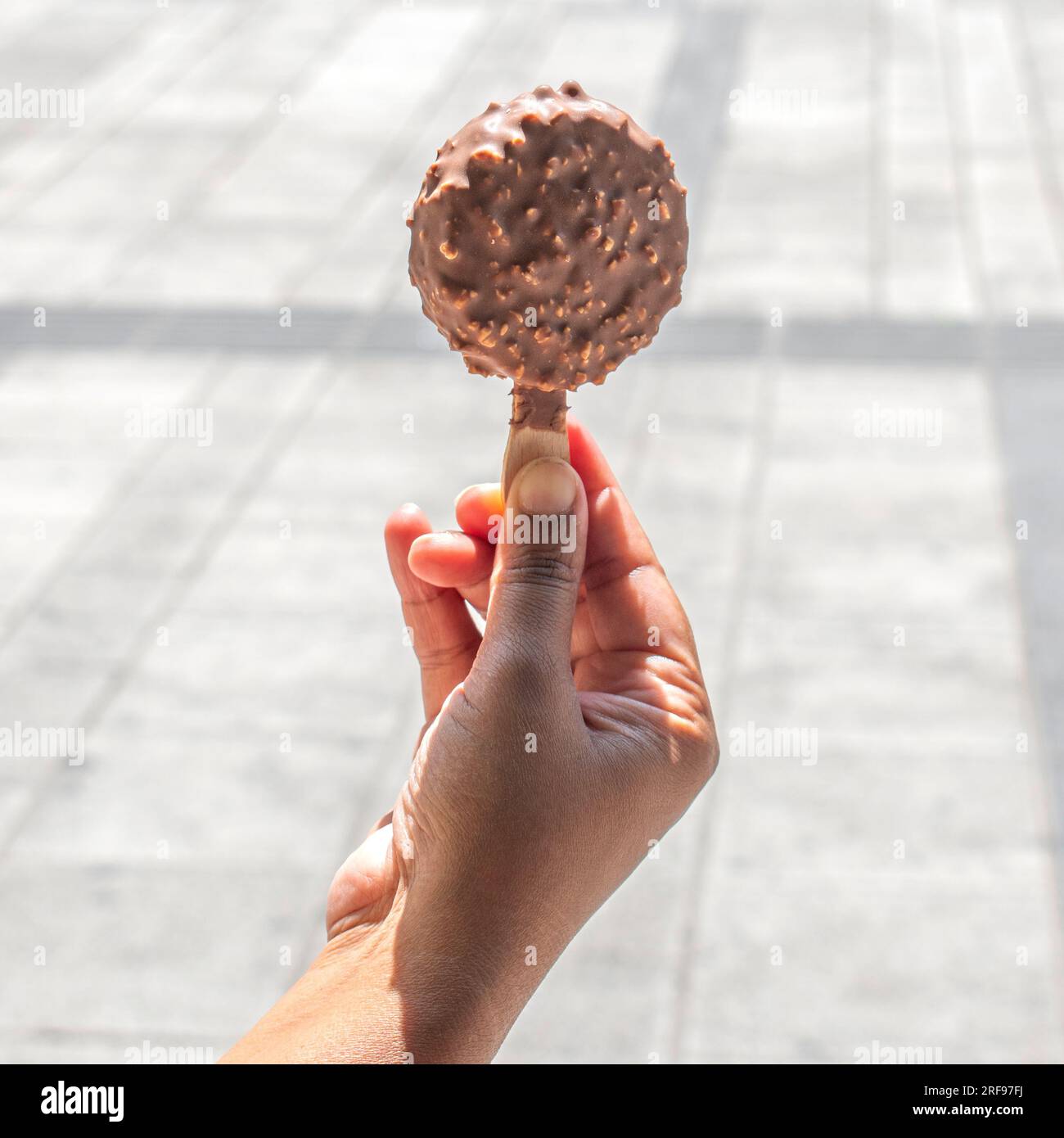 Schokoladeneis mit Haselnuss und klassischer Milchschokolade. Machen Sie Fotos mit einem verschwommenen öffentlichen Ort als Hintergrund Stockfoto
