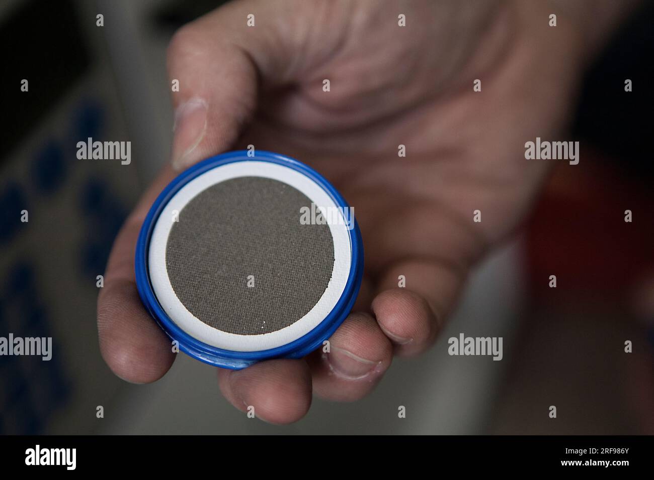 Die Luftqualität analysiert: Metallfilter, der weiße Rand zeigt die Farbe des Filters vor der Verwendung an. Stockfoto