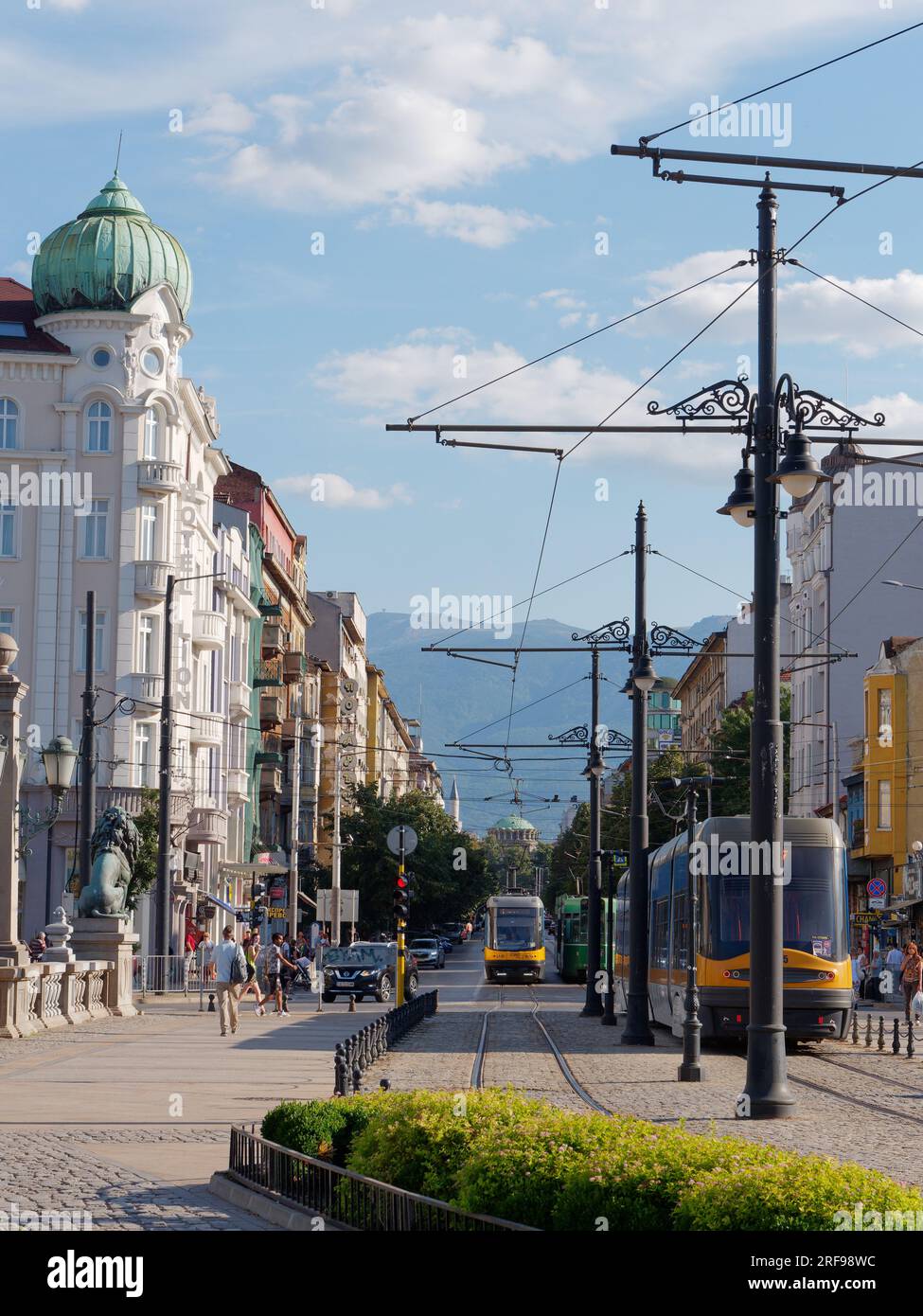 Straßenbahn auf der Löwenbrücke mit Boulevard Knyaginya Maria-Luiza, Banya Bashi Moschee und Hügeln dahinter. Sofia, Bulgarien. August 2023. Stockfoto