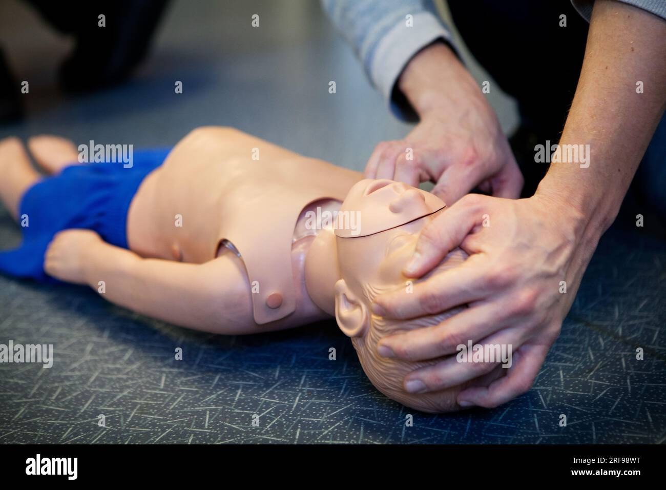 Erste-Hilfe-Training an einer Säuglingspuppe. Stockfoto