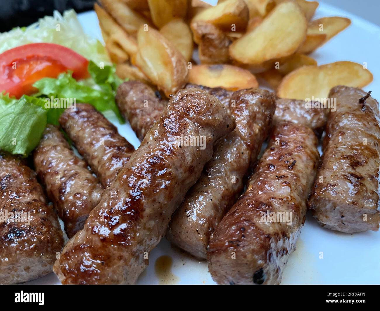 Nahaufnahme von Cevapi: Traditionelles bosnisches Grillfleisch im Detail Stockfoto