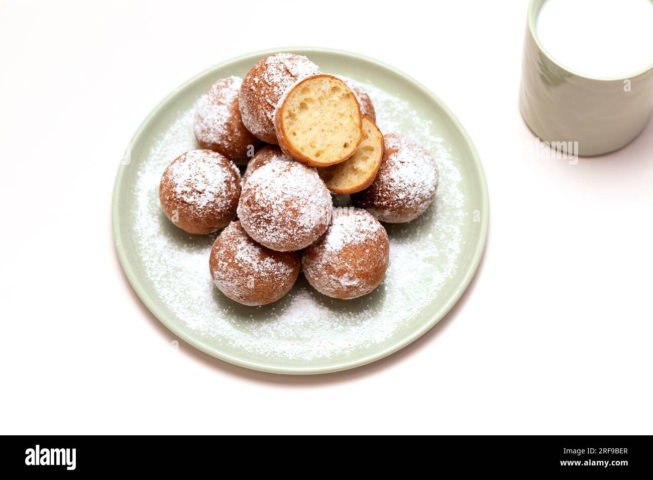 Flatly Fat Thursday Carnival oder Tlusty Czwartek, christliche Tradition. Zeppole Oder Paczki Auf Teller Mit Zuckerpulver, Tasse Milch Auf Dem Tisch. Donut Stockfoto
