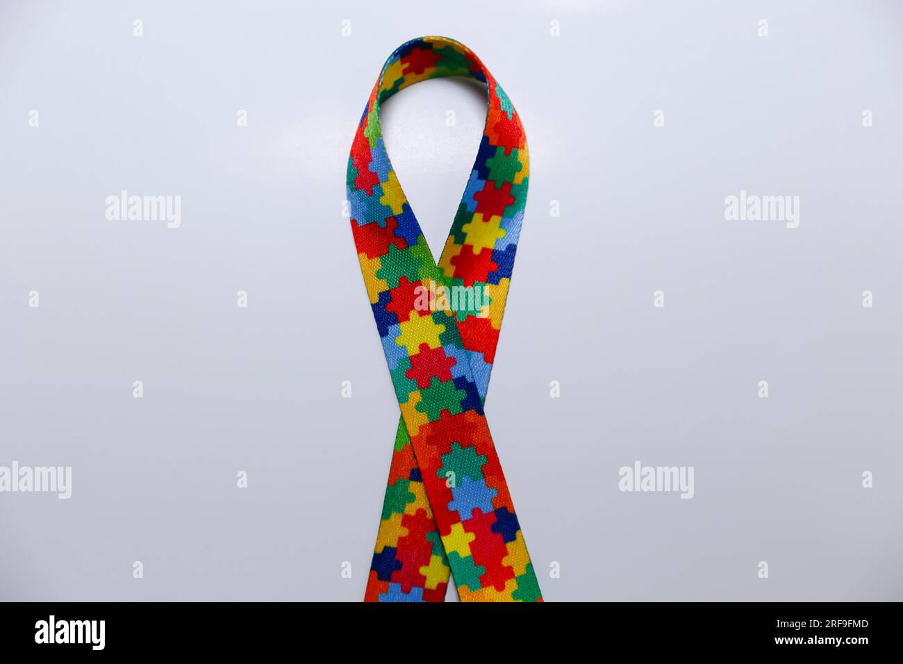 Autismus-Symbol – Farbband mit Zeichnungen von farbigen Puzzleteilen Stockfoto