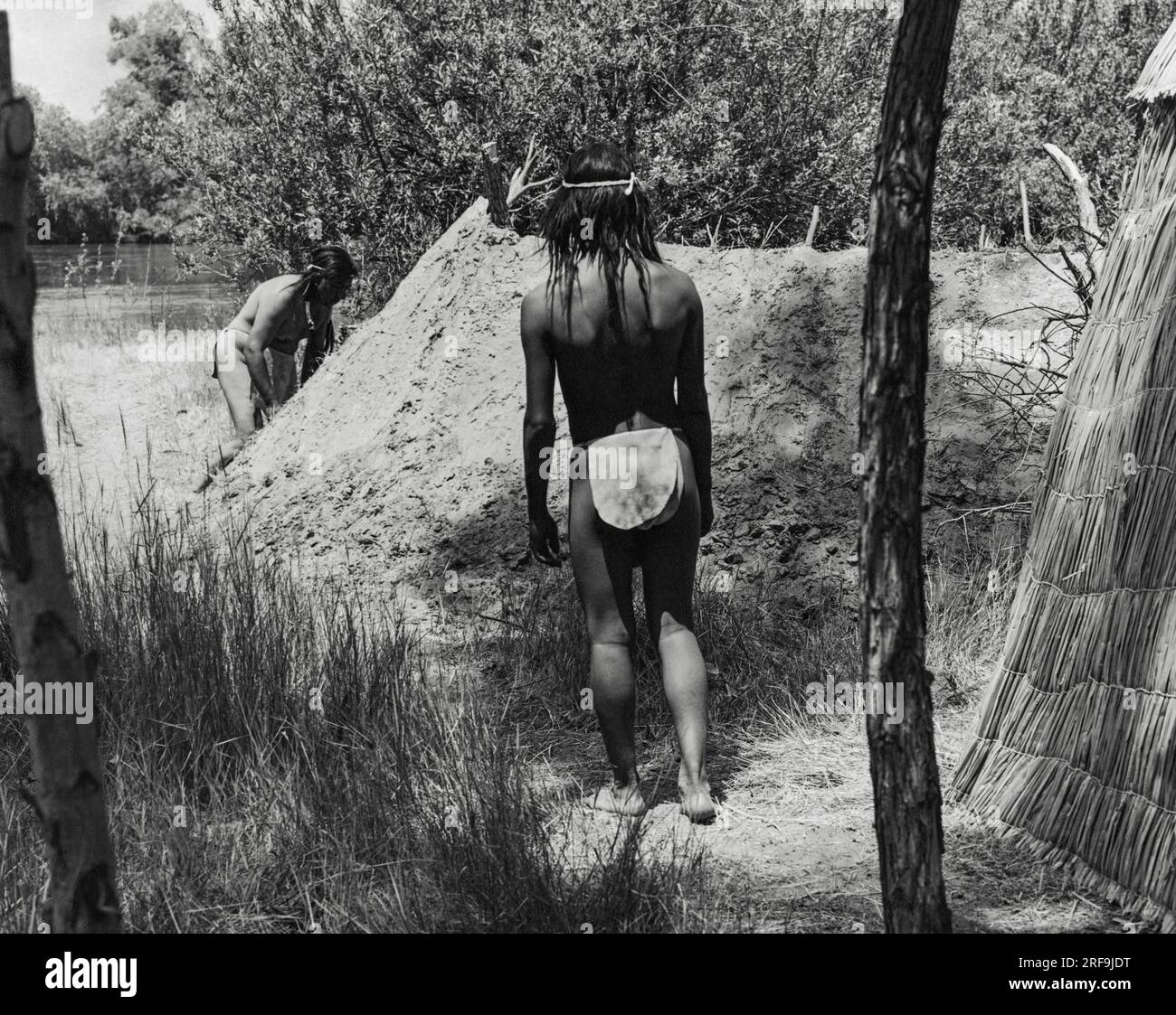 Kalifornien: ca. 1930 die meisten kalifornischen indianischen Dörfer hatten ein oder mehrere Schwitzhäuser, in denen sich die Männer täglich versammelten, um den traditionellen Brauch des Schwitzens zu genießen. Das erdbedeckte Haus wurde in der Nähe des Flusses gebaut, damit die Männer nach dem Schwitzen ins Wasser springen konnten. Stockfoto