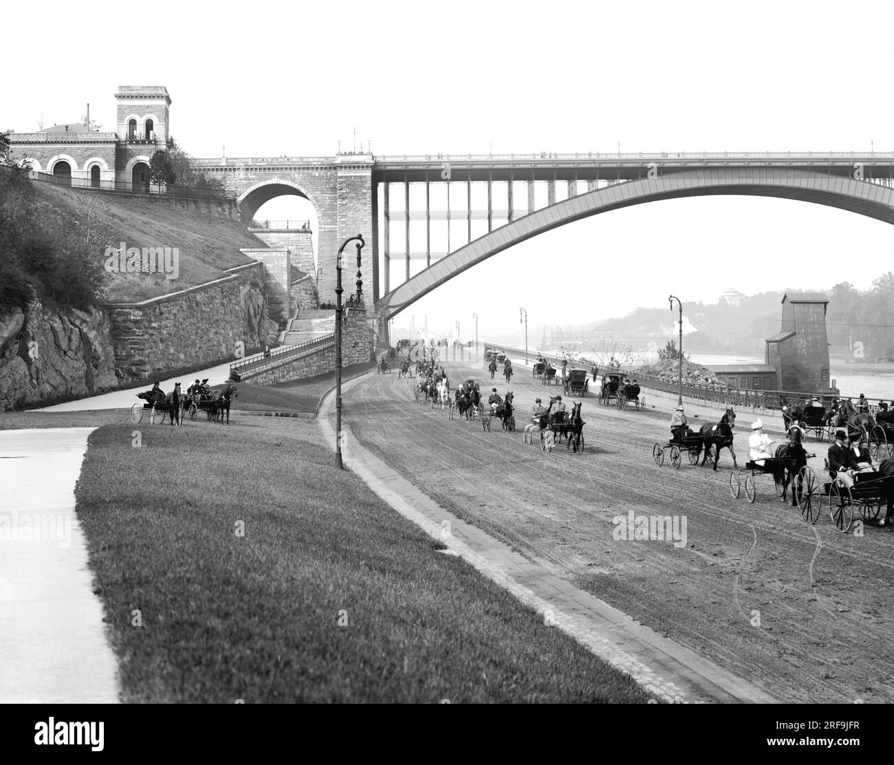 New York, New York: ca. 1905 Ein Blick auf den Harlem River Speedway mit der Washington Bridge im Hintergrund. Es war ursprünglich nur für Kutschen und Süße geöffnet, damit die Reichen ihre Trabrennpferde auf der 2,5 km langen unbefestigten Straße vorführen konnten. Fußgänger, Reiter und Radfahrer waren verboten. Stockfoto