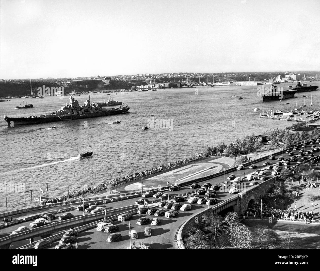 New York, New York: Ocotber 26, 1945 USA Marineschiffe vor Anker im Hudson River in Vorbereitung auf den Navy Day in New York. Das Schlachtschiff Missouri führt auf der linken Seite, und die Flugzeugträger Enteprise und Midway folgen dahinter. Stockfoto