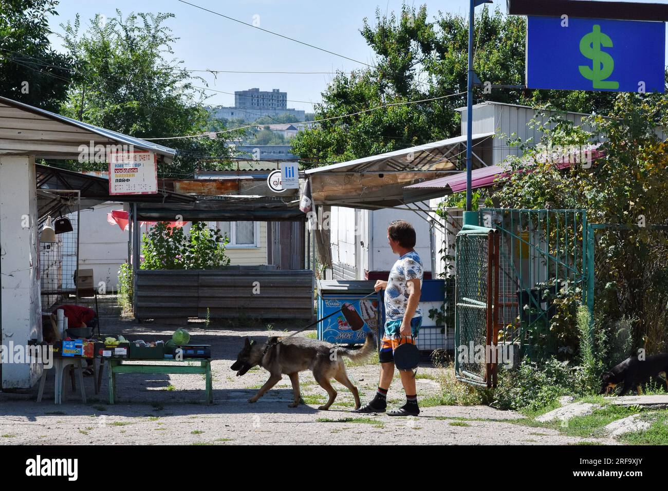 Stepnohirsk, Ukraine. 01. Aug. 2023. Ein Mann mit einem Hund, der am Lebensmittelmarkt in Stepnohirsk vorbeikommt. Die russische Aggression hat eine erhebliche humanitäre Krise verursacht. Viele Menschen und Tiere brauchen zum Überleben Grundnahrungsmittel. (Foto: Andriy Andriyenko/SOPA Images/Sipa USA) Guthaben: SIPA USA/Alamy Live News Stockfoto