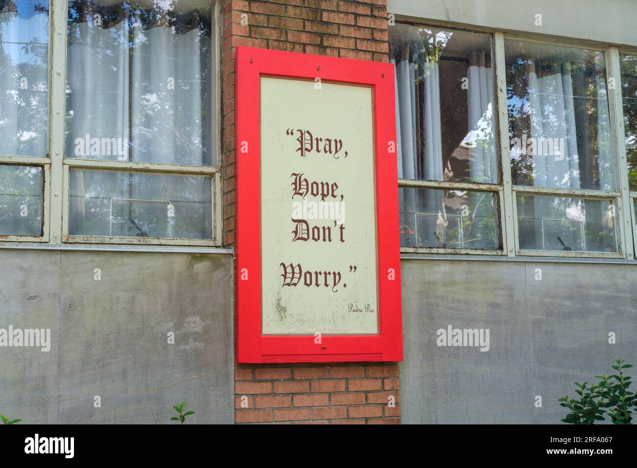 NEW ORLEANS, LA, USA - 12. MAI 2023: „Pray, Hope, Don't worry“-Schild auf der Seite des katholischen Pfarrhauses der Hook Dolorosa Stockfoto