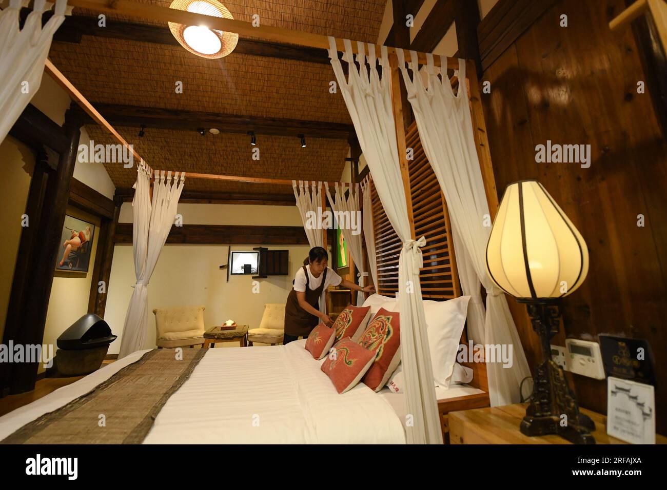 Jinhua, Chinas Provinz Zhejiang. 1. Aug. 2023. Ein Mitarbeiter räumt ein Zimmer in einer Gastfamilie in Zhuge Village in Lanxi City, Ost-Chinas Provinz Zhejiang, am 1. August 2023 auf. Das Zhuge Village, ein historisches Juwel mit über 300 antiken Gebäuden aus den Ming- und Qing-Dynastien (1368-1911), beherbergt Nachkommen von Zhuge Liang, einem bekannten Militärstrategen in der Dreikönigszeit (220-280). Das Dorf hat gemeinsame Anstrengungen unternommen, um das alte Erbe zu erhalten und den Tourismus zu entwickeln, und nimmt jährlich über 500.000 Besucher auf. Kredit: Weng Xinyang/Xinhua/Alamy Live News Stockfoto