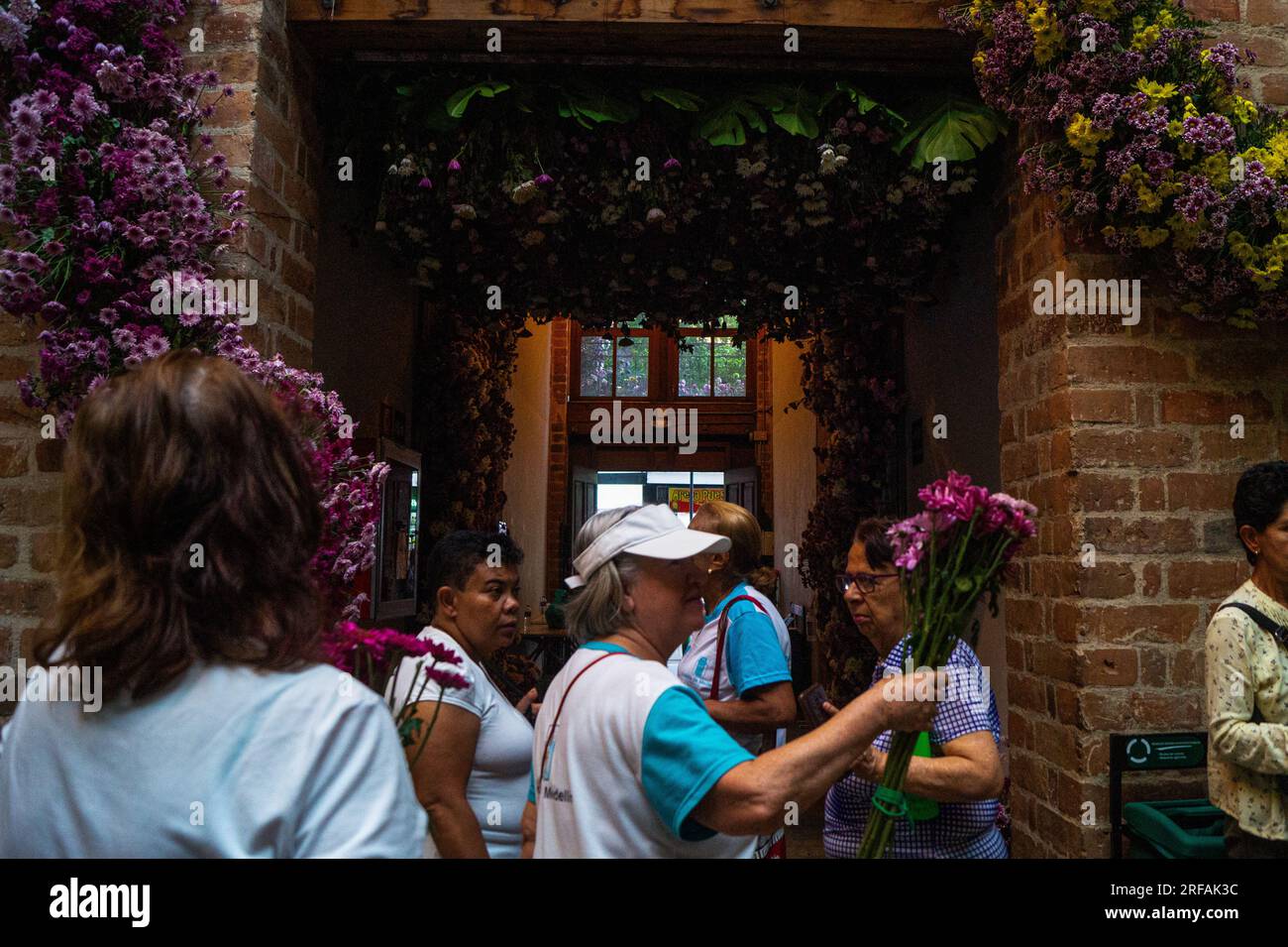 Medellin, Kolumbien. 31. Juli 2023. Menschen posieren für Fotos, da das berühmte Vasquez-Gebäude gefüllt ist mit Blumen für die „Feria de las Flores“ in Medellin, Kolumbien, 31. Juli 2023. Foto: Jessica Patino/Long Visual Press Credit: Long Visual Press/Alamy Live News Stockfoto