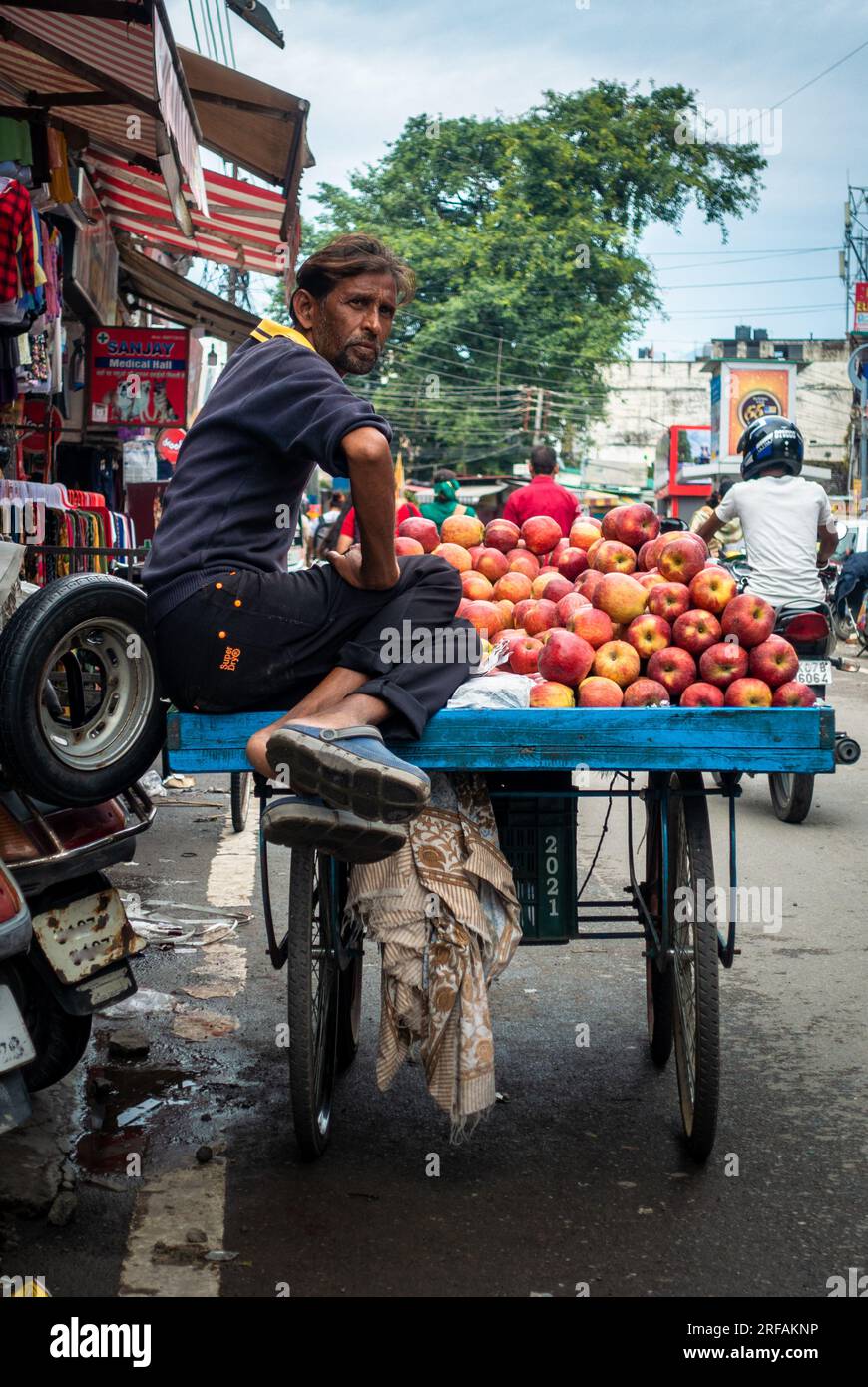 Oktober 14. 2022 Uttarakhand, Indien. Fesselnde Straßenfotografie in Dehradun City: Straßenverkäufer, der frische rote Äpfel von einem Handwagen verkauft. Stockfoto
