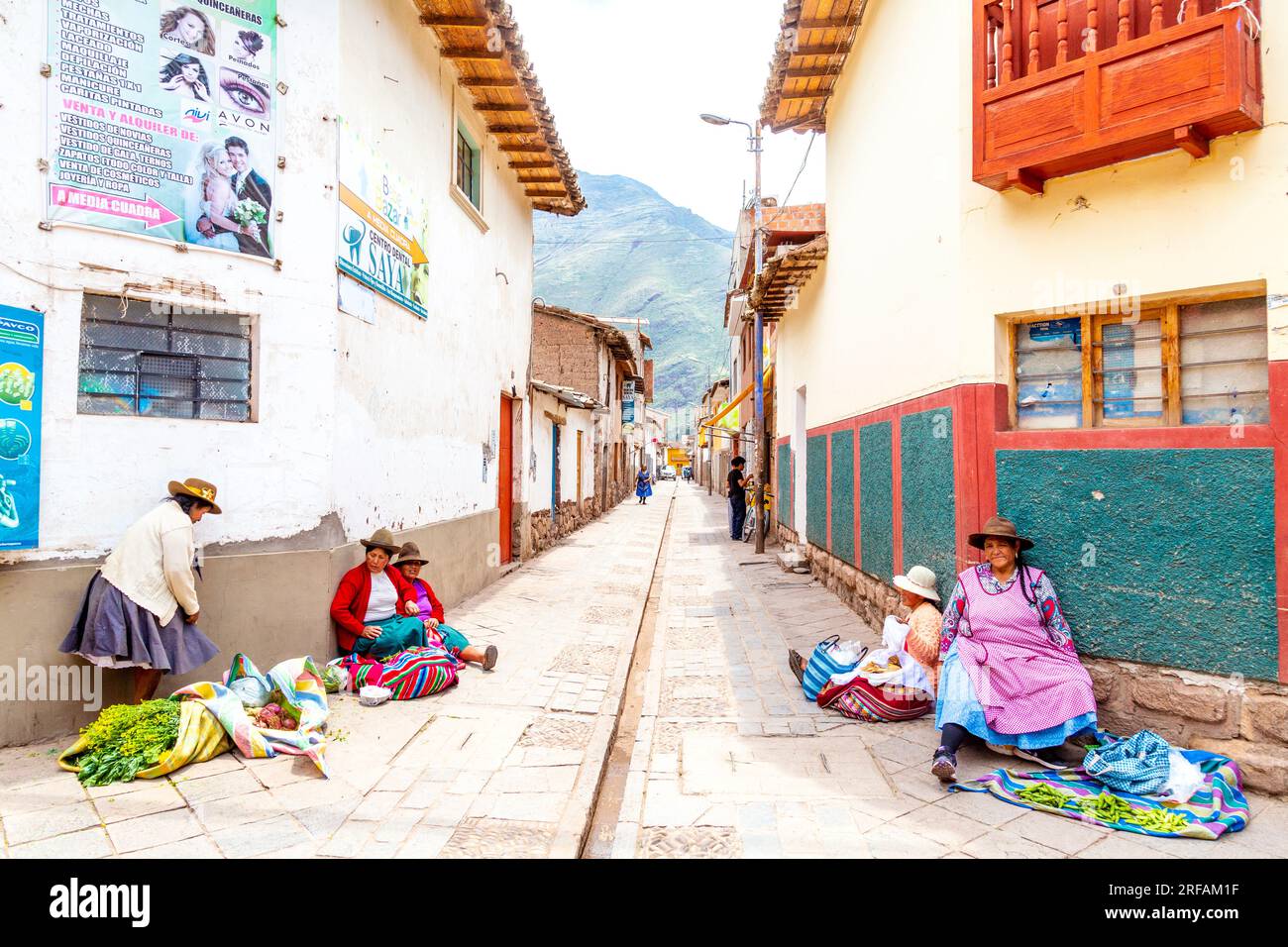 Eine peruanische Frau, die auf dem Boden sitzt und Sachen in Pisac, Heiliges Tal, Peru verkauft Stockfoto