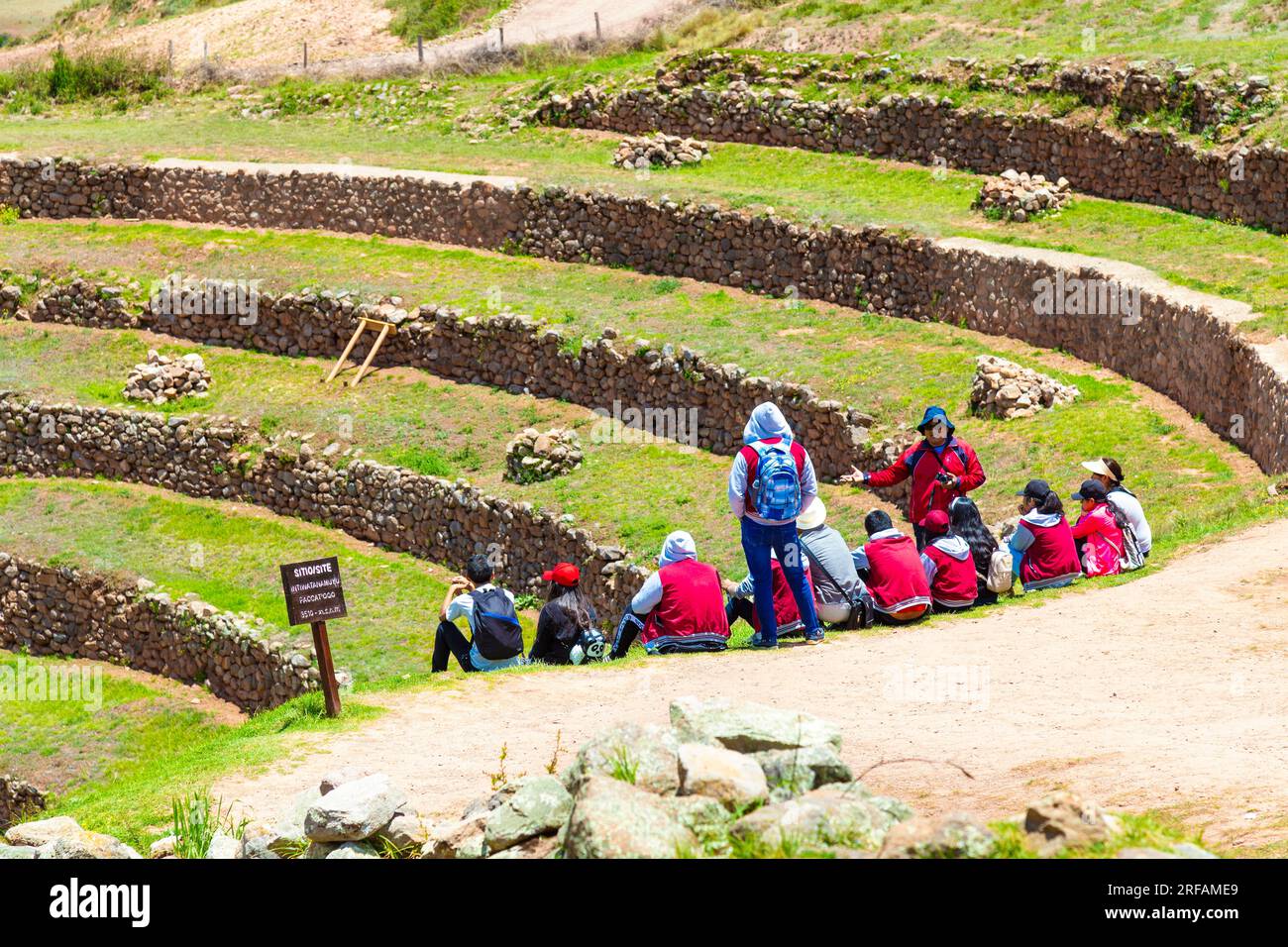 Eine Reisegruppe mit Reiseleiter, die sich die Terrassen der archäologischen Inka-Stätte in Moray, Heiliges Tal, Peru anschaut Stockfoto