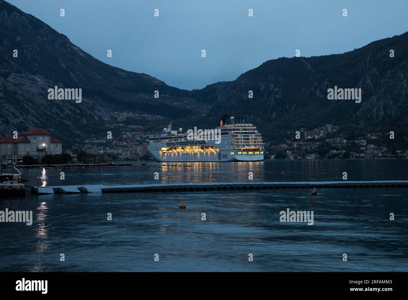 Kotor, Montenegro, 16. April 2023: Kreuzfahrtschiff MSC ARMONIA vor Anker in der Bucht von Kotor in der Abenddämmerung Stockfoto
