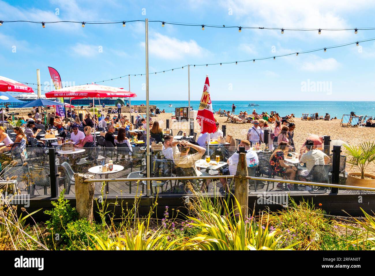 Gäste können an sonnigen Tagen im Ohso Social Beach Bar and Restaurant im Freien in Brighton, East Sussex, England speisen Stockfoto