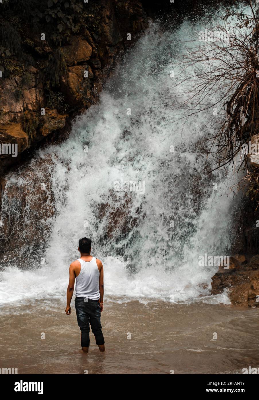 Oktober 14. 2022 Uttarakhand, Indien. Ein glücklicher Mann, der einen Blick aus nächster Nähe auf einen malerischen Wasserfall in den Außenbezirken von Dehradun City genießt. Die Schönheit der Natur in ihrer B Stockfoto