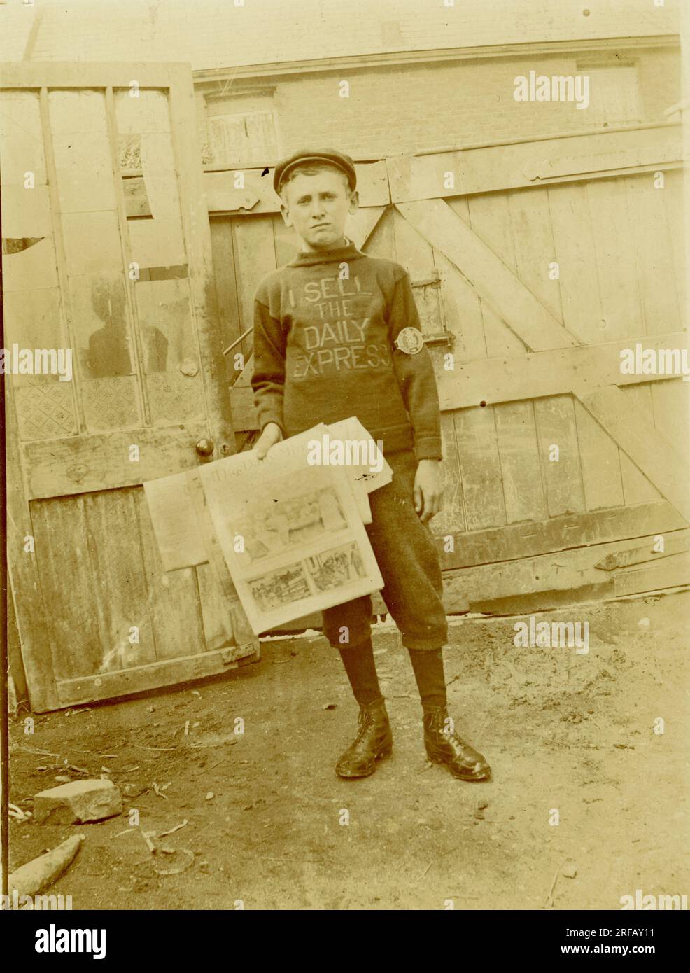 Originale Titanic-Postkarte eines Zeitungsverkäufers im Teenageralter, trägt einen "Ich verkaufe den Daily Express"-Pullover, aber mit der Daily Mirror-Lizenz Nr. 98. Möglicherweise Liverpool, etwa 1912, Großbritannien Stockfoto
