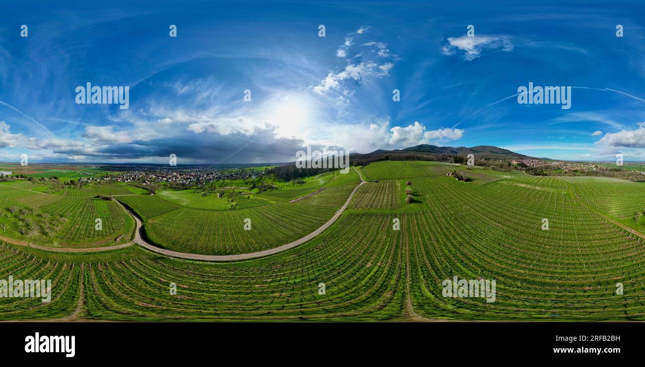 360 Panoramaaussicht aus der Vogelperspektive über den Dörfern Uffholtz und Wattwiller grüne Weinberge in einem Elsässer Tal bei sonnigem Tag mit blauem stürmischem Himmel Stockfoto