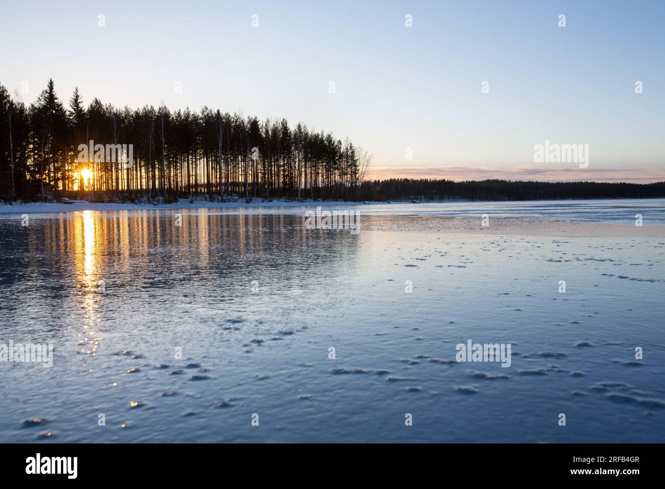 Winter in finnland, gefrorener See, Sonnenuntergang, Landschaftstapete Stockfoto