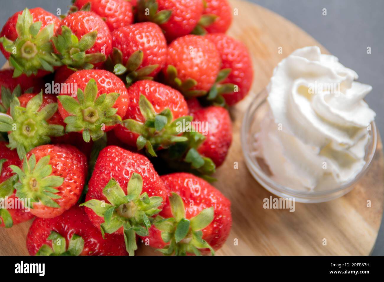 Foto von frischen, reifen Erdbeeren mit Sahne, Seitenansicht von oben Stockfoto