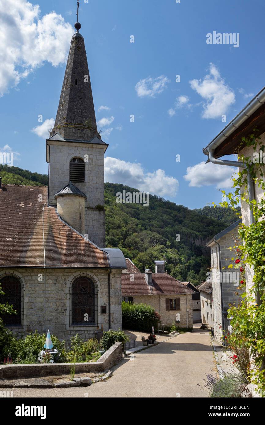 Das malerische Dorf Lods und die Kirche St. Theodule im Departement Doubs in Bourgogne-Franche-Comté in Frankreich. Bereich oben rechts kopieren. Stockfoto