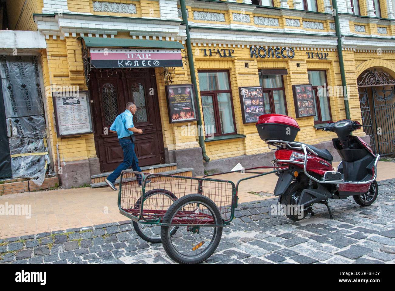 KIEW, UKRAINE - 30. JULI 2023 - Ein Roller mit Anhänger parkt in Andriivskyi Descent vor dem Koleso Theater im historischen Viertel von Stockfoto
