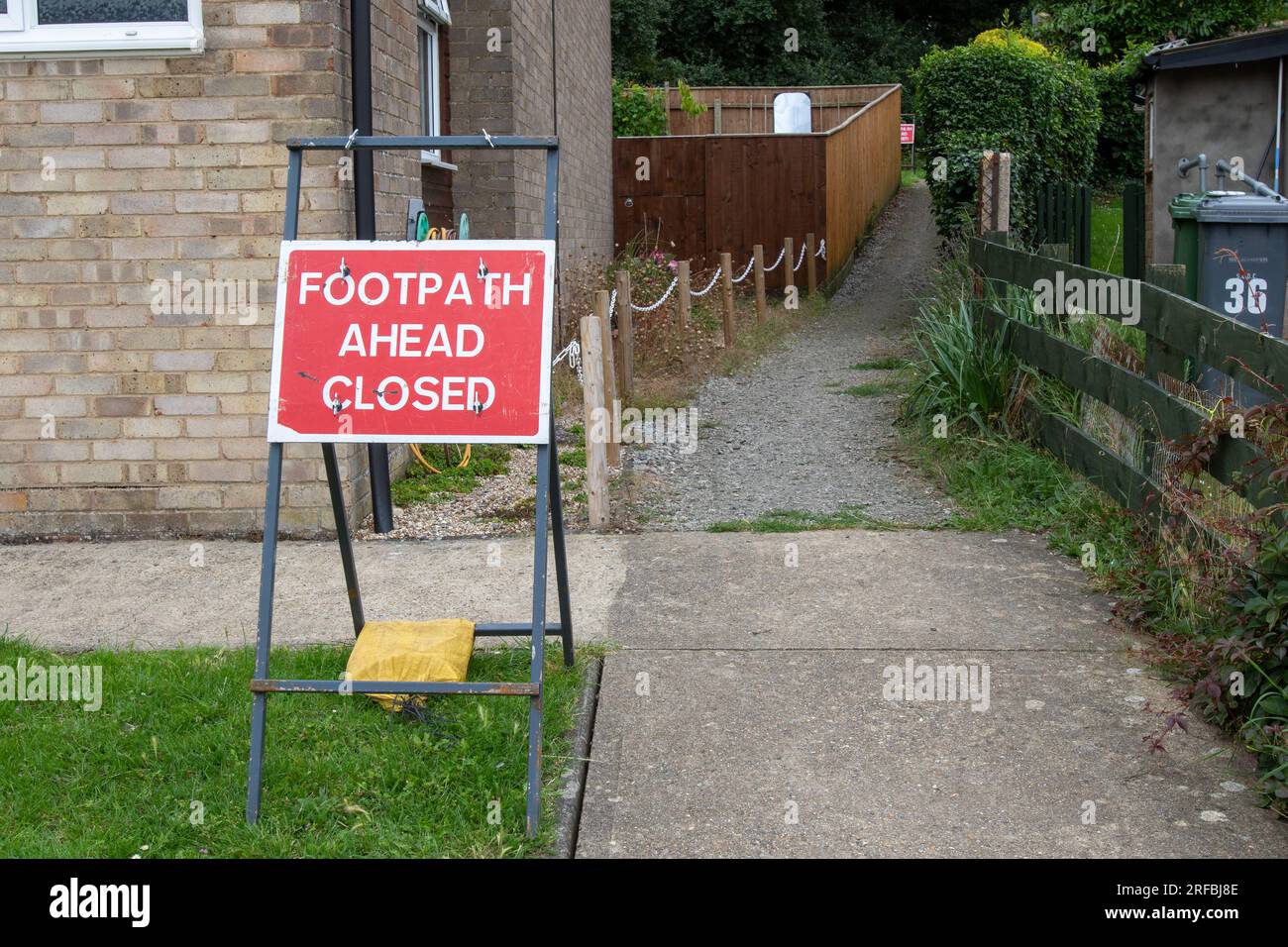 Ein rotes und weißes Warnschild, dass ein öffentlicher Fußweg wegen Bauarbeiten geschlossen ist Stockfoto