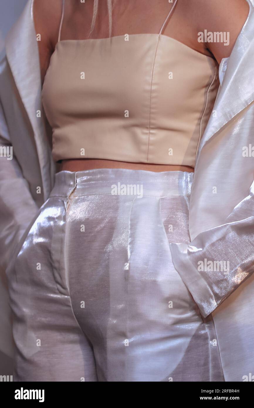 Verkürzte Modefigur in trendigen weißen Kostümen, Jacken, Hosen und Oberteil. Modisches, trendiges Outfit, Damenbekleidungskonzept. Stockfoto