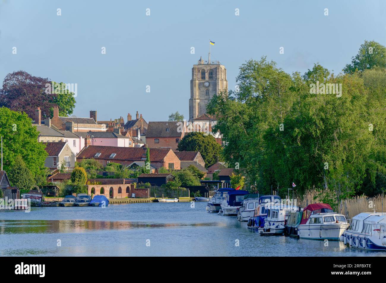 Blick auf festgemachte Boote und die Kirche auf dem Fluss Waveney in Beccles, Suffolk, England, Großbritannien Stockfoto