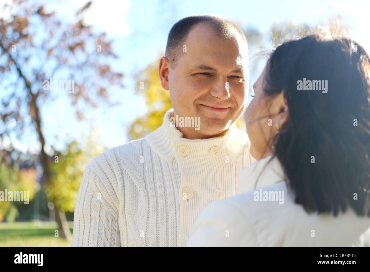Mann und Frau auf einem Spaziergang im Herbstpark. Das Paar schaut sich liebevoll an. Horizontales Foto Stockfoto