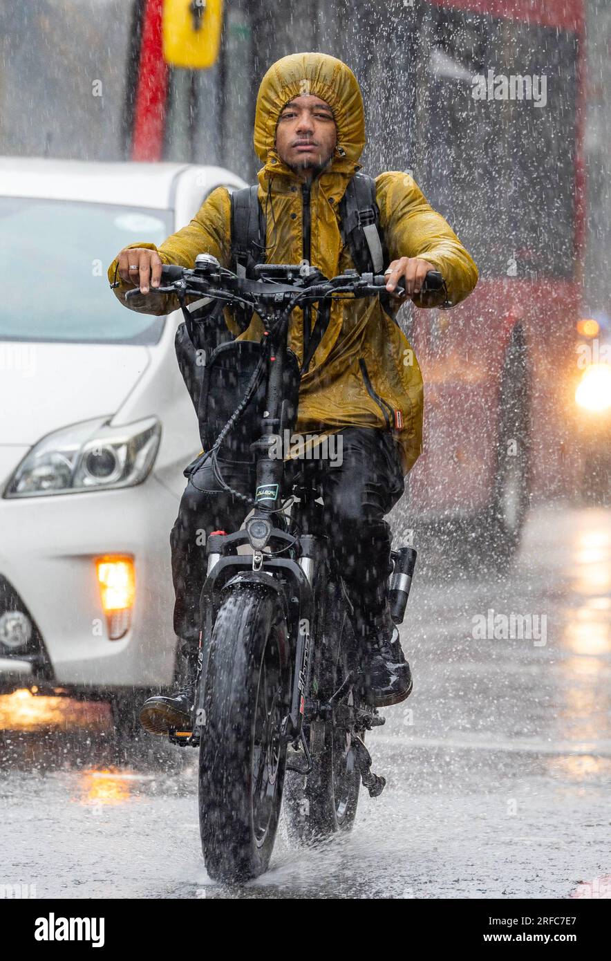 Fotoshows: Nasser August harte Fahrt ohne Visier auf dem E-Bike nasses Wetter in London, da schwere Schauer und Stürme die Hauptstadt 2.8.23 heimsuchten Pi Stockfoto