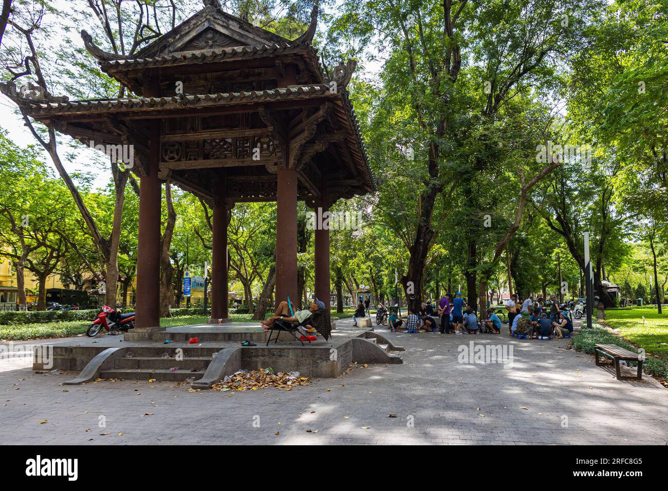 Hanoi, Vietnam - 24. Mai 2023: Lenin Park atmet Ruhe inmitten städtischer Pulsschläge. Üppiges Grün umschließt einen See, während sich Schachspieler in der Ferne versammeln Stockfoto
