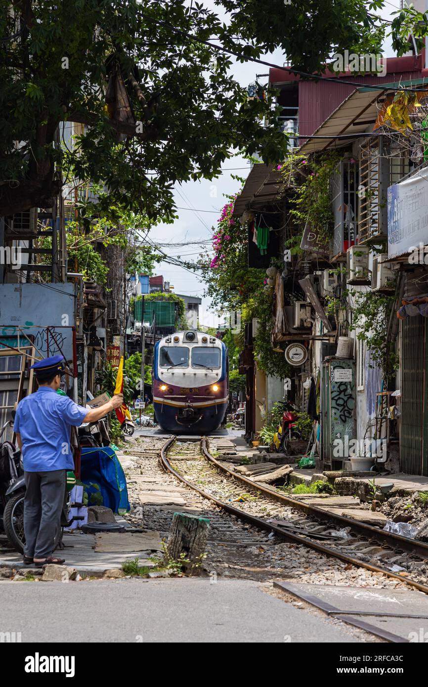 Hanoi, Vietnam - 28. Mai 2023: Train Street in Hanoi ist eine schmale, belebte Gasse mit Gleisen. Dicht gestrickte Häuser, mit Pflanzen geschmückt, sind Zentimeter entfernt f Stockfoto