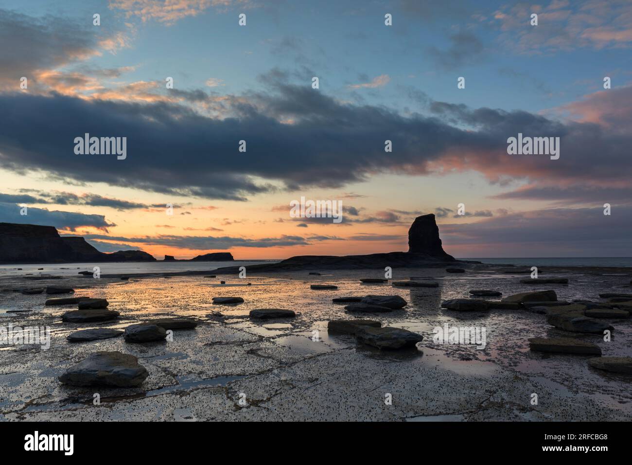 Sommersonnenuntergang in der Saltwick Bay mit dem Black NAB, geologische Formation, North Yorkshire Coast Stockfoto