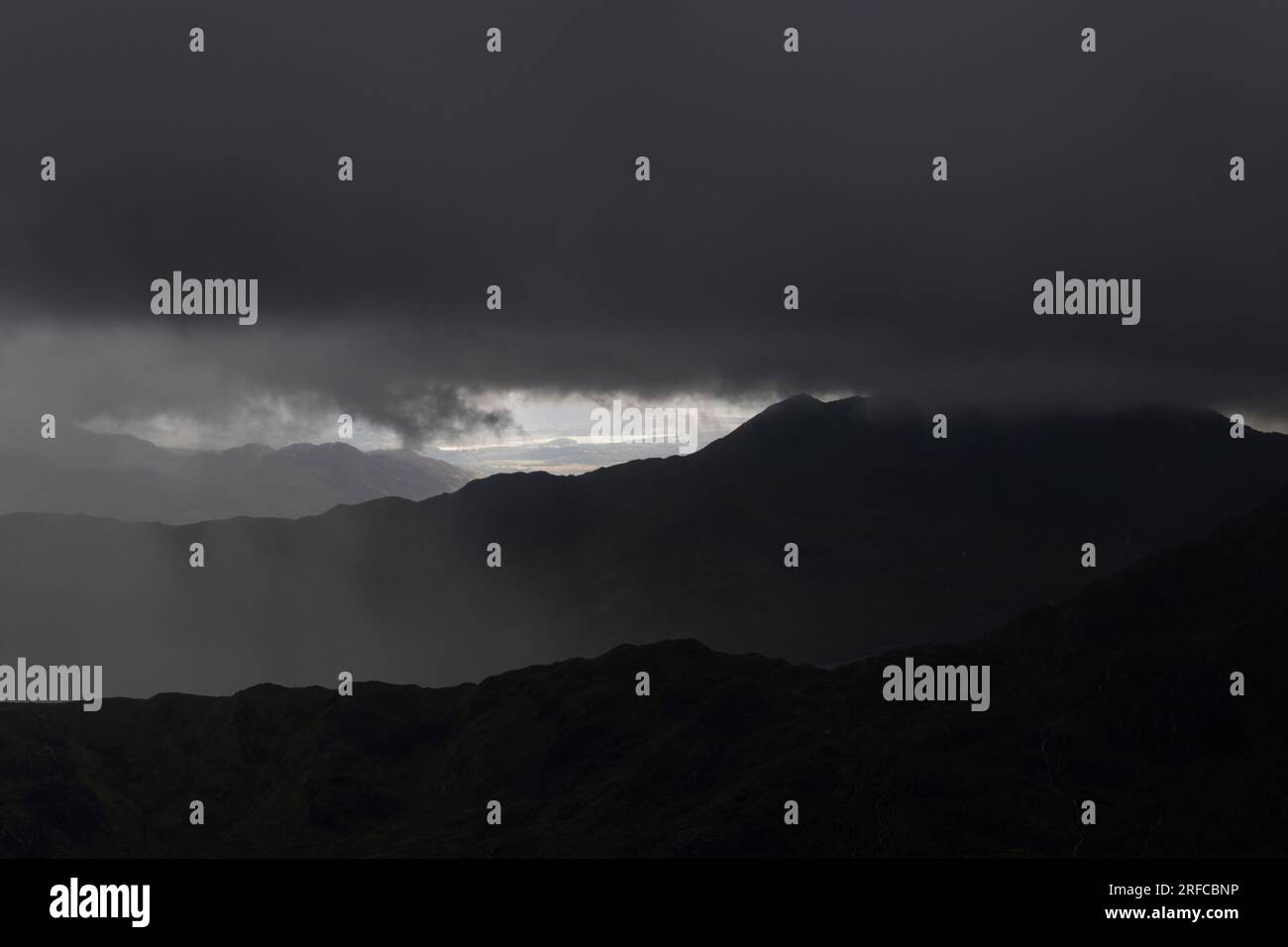 Blick hinüber nach Snowdon, das in dicken schwarzen Wolken verborgen ist, bildet den Gipfel des Glyder Fach, Snowdonia National Park, Wales Stockfoto
