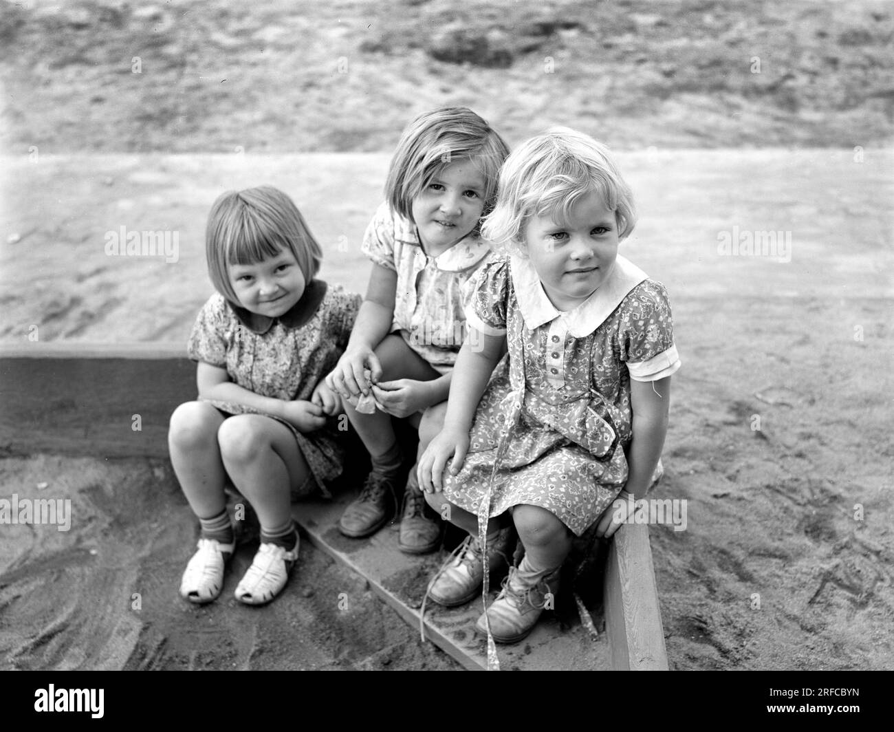 Drei Kinder spielen in Sandbox, Tulare Migrant Camp, Visalia, Kalifornien, Arthur Rothstein, USA Farm Security Administration, März 1940 Stockfoto
