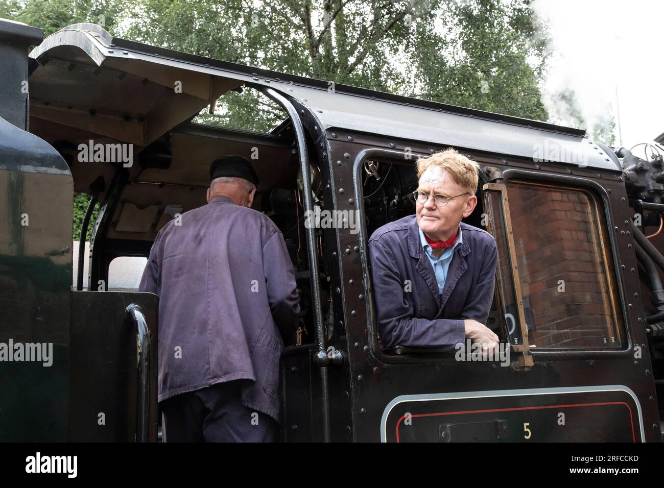 Dampflokfahrer und Feuerwehrmann auf der Fußplatte der 73156 British Railways Klasse 5MT Lokomotive an der historischen Bahnlinie des Bahnhofs Loughborough Stockfoto