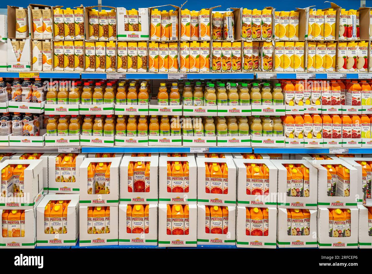 Italien - 02. August 2023: Fruchtsäfte in Plastikflaschen und in Kartons, die in Regalen zum Verkauf in einem italienischen Supermarkt stehen Stockfoto