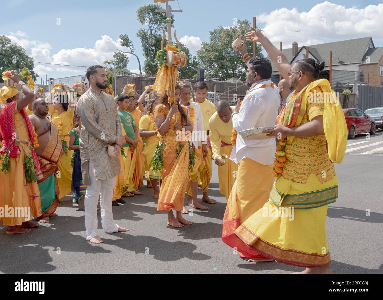 Während der Parade vom Shri Shaktii Mariammaa Tempel zum Feuerspaziergang schlägt ein pandit eine Kokosnuss in den Boden. In Richmond Hill Queens NY Stockfoto