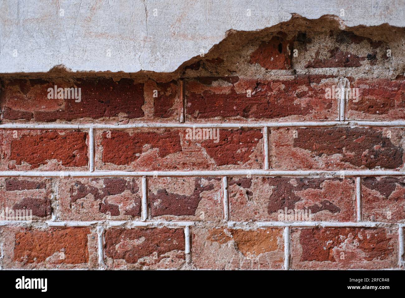 Graue Beton- und rote Ziegelwand zerstört, Platz für Text. Horizontales Foto Stockfoto