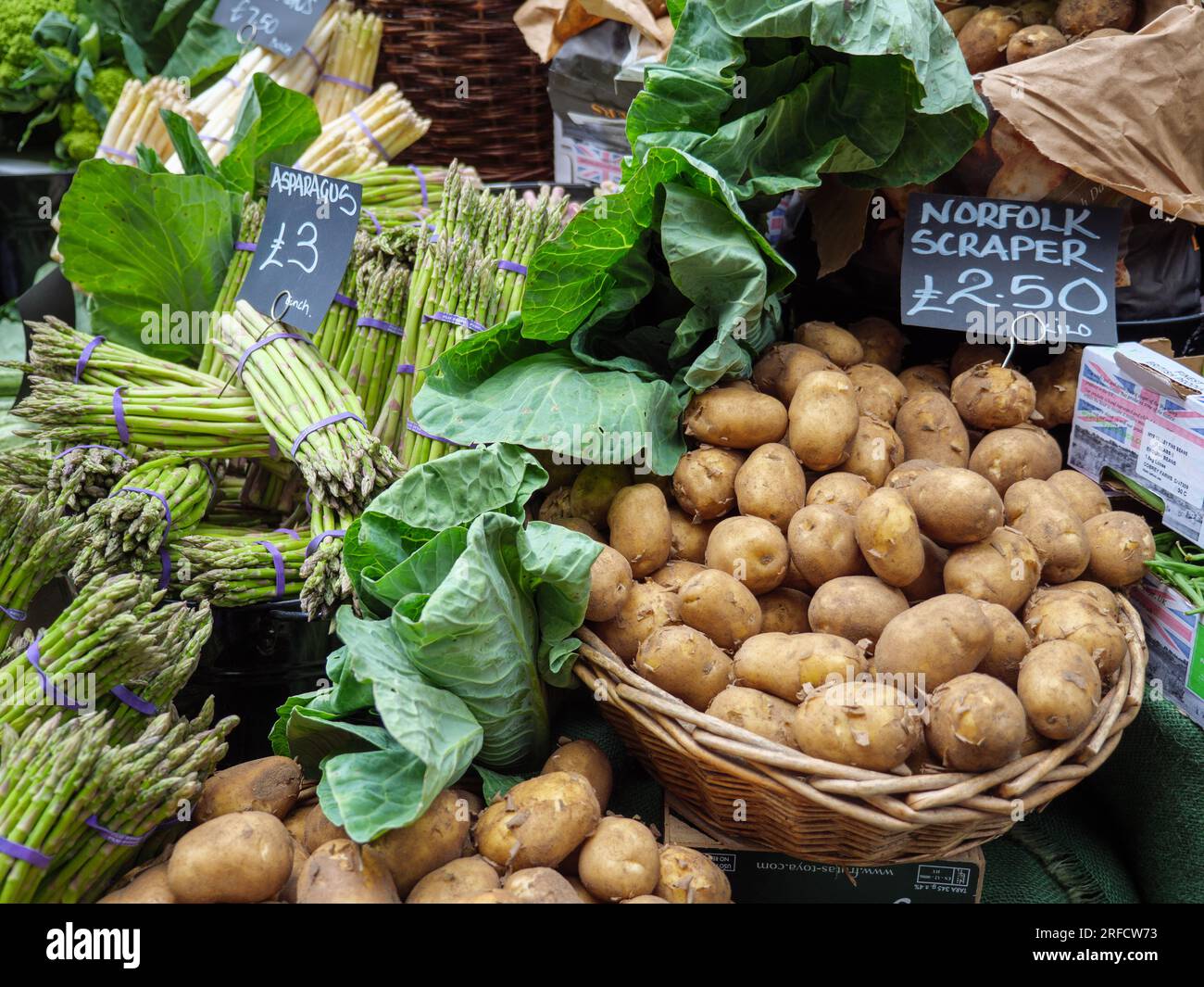 Britischer Gemüsestand mit Spargel und Kartoffeln im Borough Market, London, Großbritannien Stockfoto