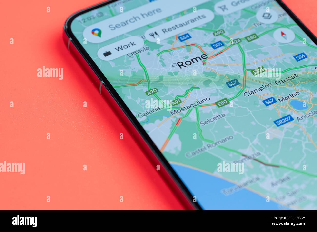 New York, USA - 21. Juli 2023: Verkehrsaufkommen in Rom in google Maps auf dem Smartphone-Bildschirm Nahaufnahme mit rotem Hintergrund Stockfoto
