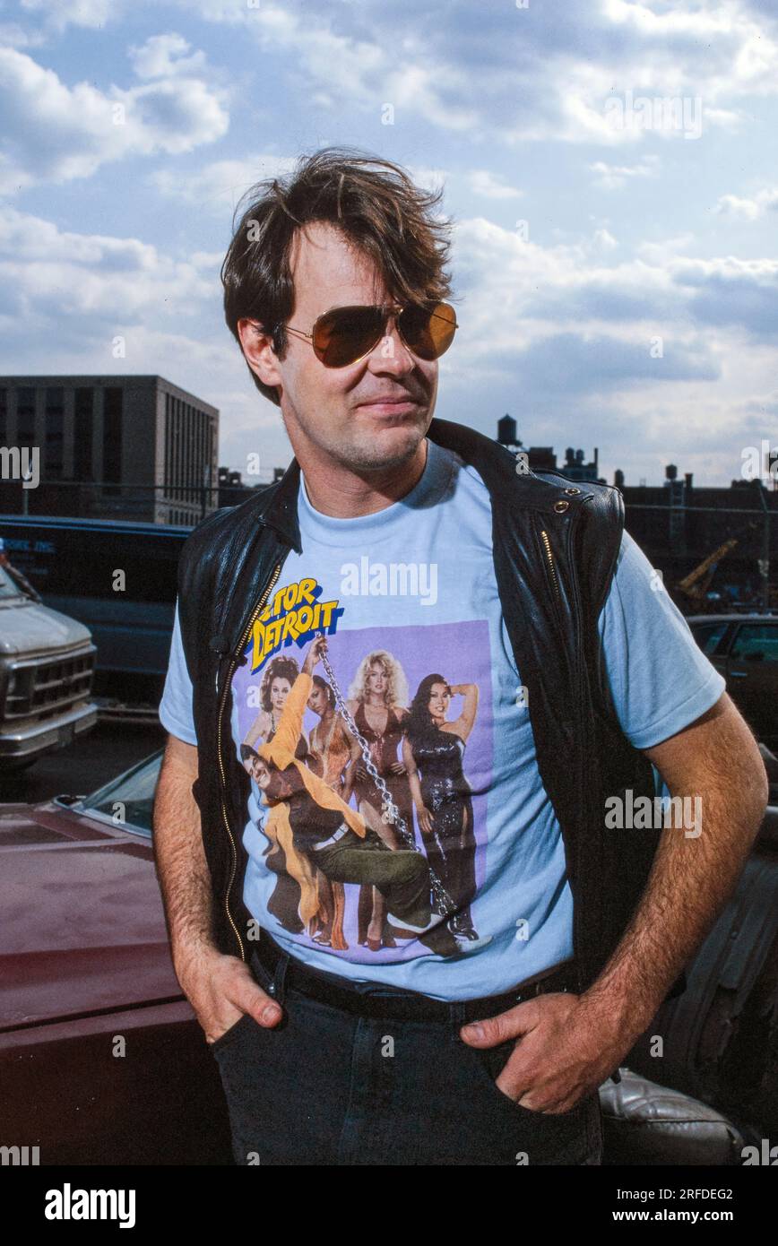 Kommedian/Schauspieler Dan Aykroyd am Drehort 1982. Bernard Gotfryd Foto. Daniel Edward Aykroyd ist ein kanadischer Schauspieler, Komiker, Drehbuchautor, Produzent und Musiker. Aykroyd war Autor und ursprüngliches Mitglied der „Not Ready for Prime Time Players“-Besetzung der NBC-Sketch-Comedy-Serie Saturday Night Live von ihrer Gründung im Jahr 1975 bis zu seiner Abreise im Jahr 1979. Während seiner Amtszeit bei SNL erschien er in einer wiederkehrenden Reihe von Skizzen, insbesondere zu den Coneheads und den Blues Brothers. Stockfoto