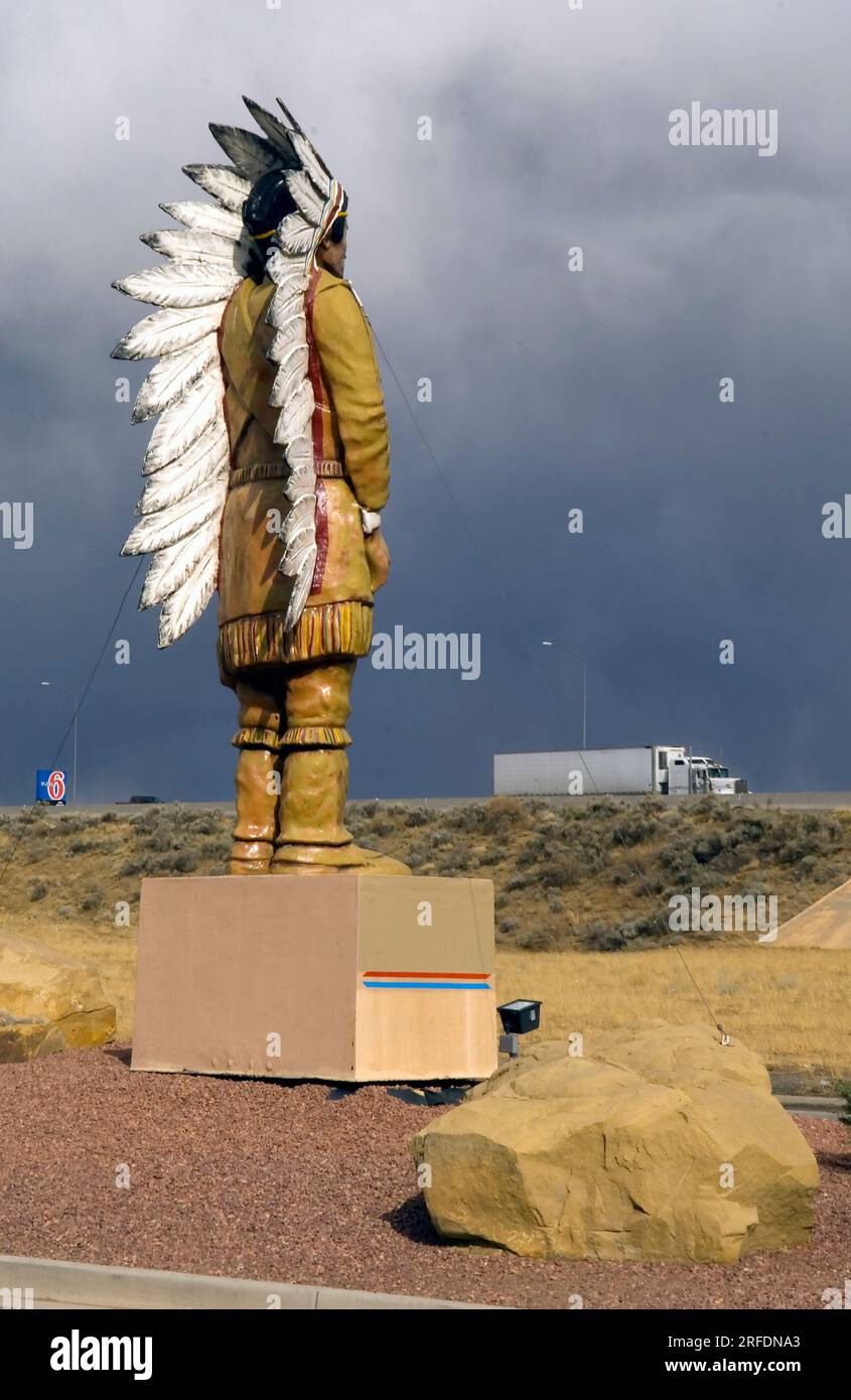 Eine Riesenfigur eines Häuptlings der amerikanischen Ureinwohner schaut auf einen großen Truck, der auf dem nahe gelegenen Interstate Highway 10 in Arizona vorbeifährt Stockfoto