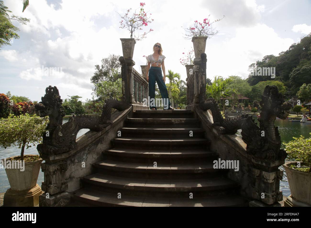 Modische Touristenfrau, die den balinesischen Königlichen Wasserpalast Tirta Gangga erkundet, Sommerurlaub auf Bali Insel Stockfoto