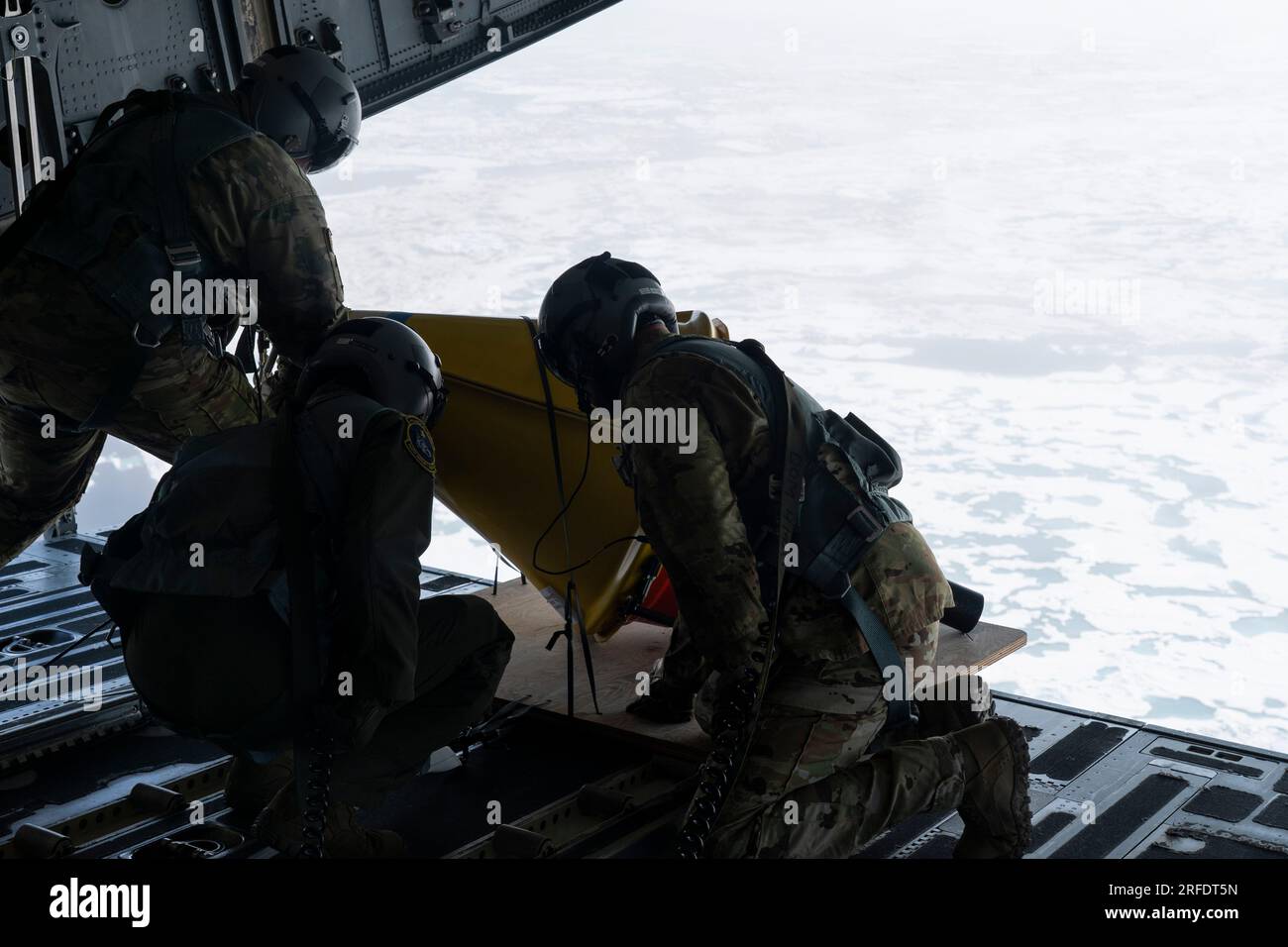 Von links nach rechts: Alaska Air National Guard Senior Master Sgt. Brian Johnson, Tech. Sgt. Chris Eggleston und Senior Master Sgt. Cecil Dickerson, Lastmeister der 144. Luftschleusenstaffel auf der Joint Base Elmendorf-Richardson, bereiten sich auf den Einsatz einer AXIB-Boje (Air-Deployable Expenable Ice Booy) während einer Abwurfmission über dem Arktischen Ozean vor, 12. Juli 2023. Das Office of Naval Research hat sich mit dem 144. ZUSAMMENGETAN, um fünf verschiedene Arten von Datenerfassungsbojen über mehr als 1.000 Seemeilen des Arktischen Ozeans zu verteilen. (USA Air Force Foto von Airman 1. Class Shelimar Rivera Rosad Stockfoto