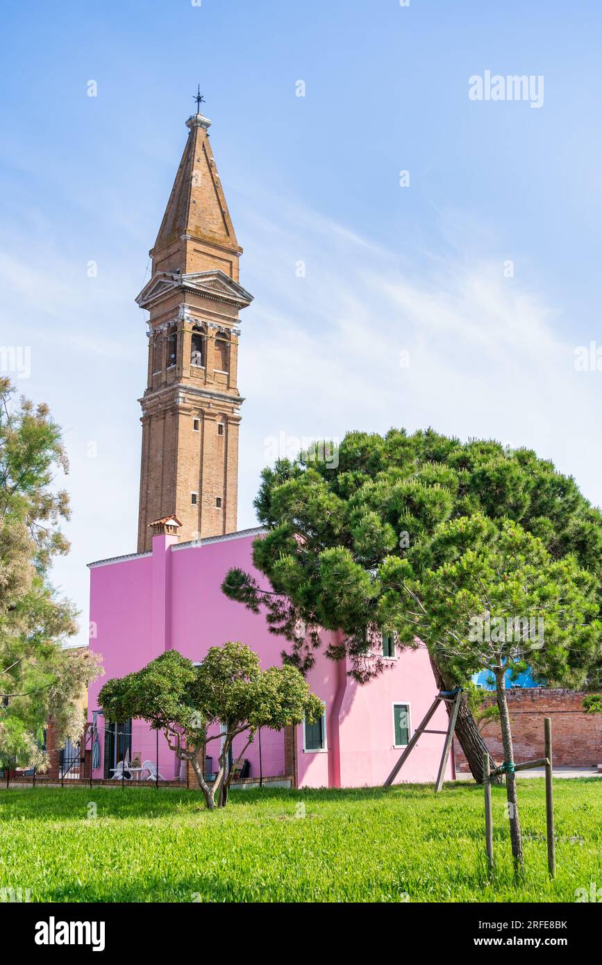 Farbenfrohe Häuser entlang des Wasserkanals mit dem schiefen Glockenturm in der Nähe der Kirche St. Martin Bishop auf der Insel Burano, Venedig. Stockfoto