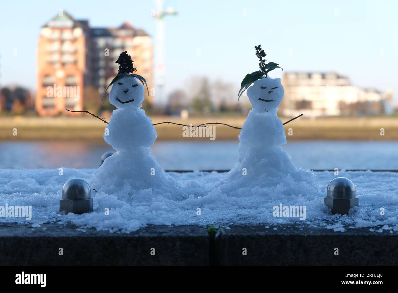Zwei Schneemänner in einer Winter- und Schneeszene. Die Themse im Hintergrund. Ein schönes romantisches Bild mit einem weichen Look und traumhafter Qualität. Stockfoto
