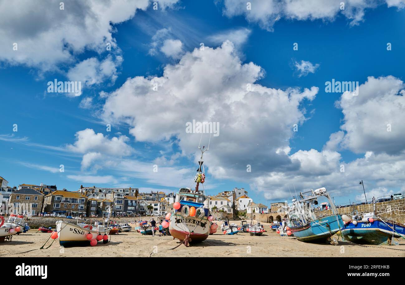 Fischerboote im Hafen von St. Ives, Cornwall vor einem dramatischen bewölkten Himmel Stockfoto