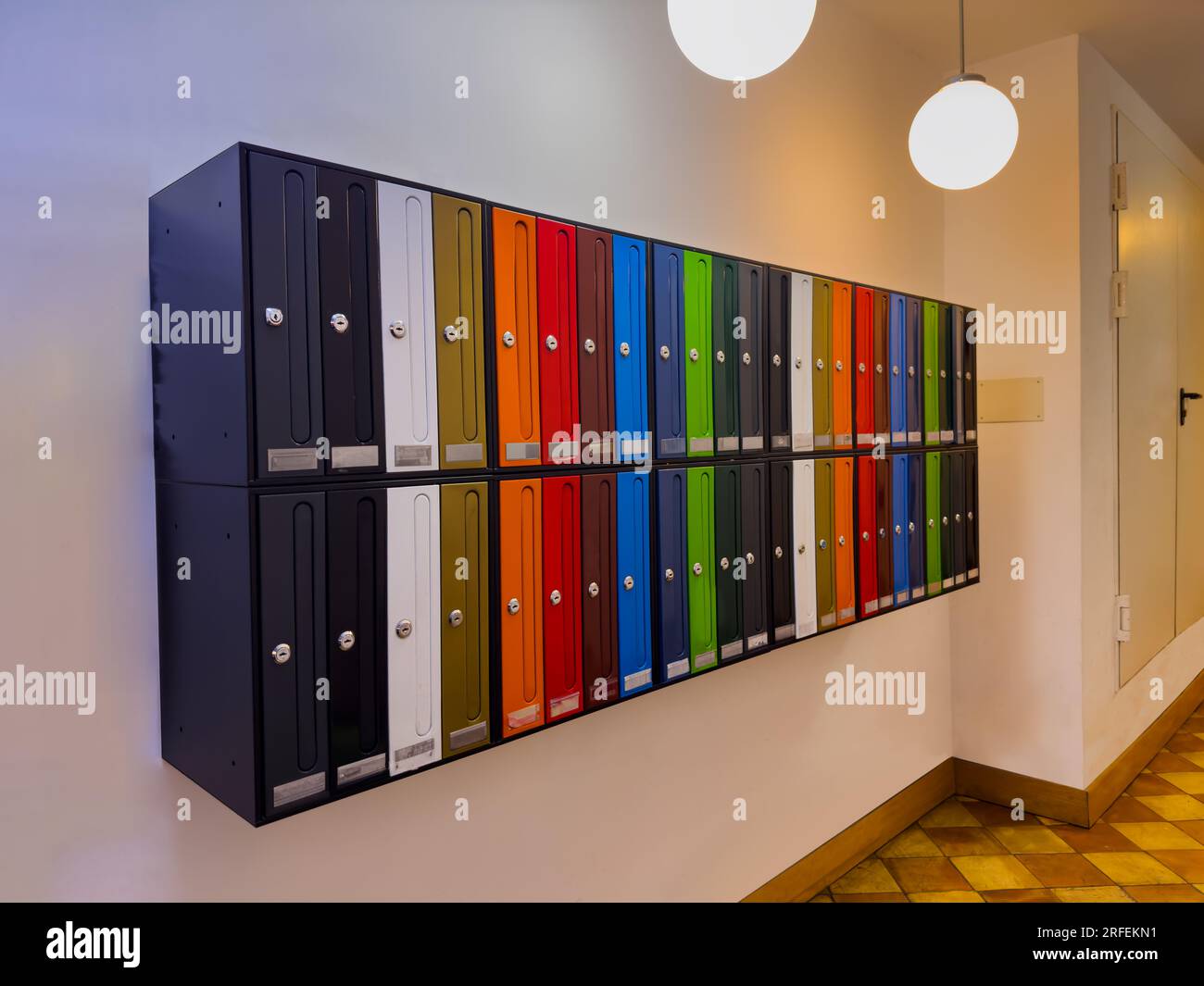Eine Gruppe bunter Briefkästen im spanischen Wohnungsgebäude Stockfoto